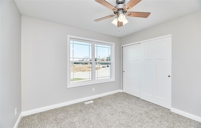 unfurnished bedroom with light carpet, a closet, and ceiling fan