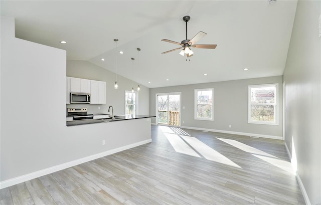 unfurnished living room with ceiling fan, high vaulted ceiling, sink, and light hardwood / wood-style floors