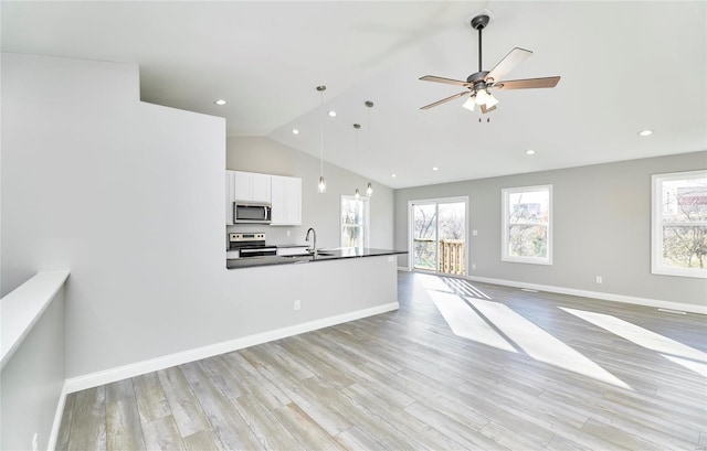 unfurnished living room with vaulted ceiling, ceiling fan, sink, and light hardwood / wood-style flooring