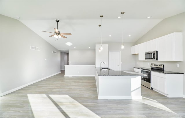 kitchen with appliances with stainless steel finishes, pendant lighting, an island with sink, sink, and white cabinets