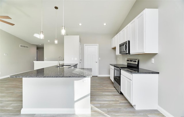 kitchen featuring pendant lighting, white cabinetry, stainless steel appliances, and dark stone counters