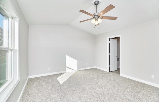 empty room featuring lofted ceiling, light colored carpet, and ceiling fan