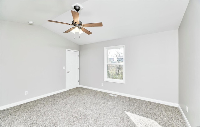 carpeted spare room featuring ceiling fan and vaulted ceiling