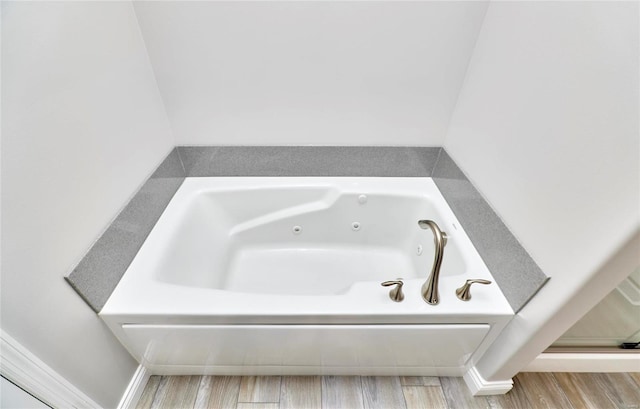 bathroom featuring wood-type flooring and a tub