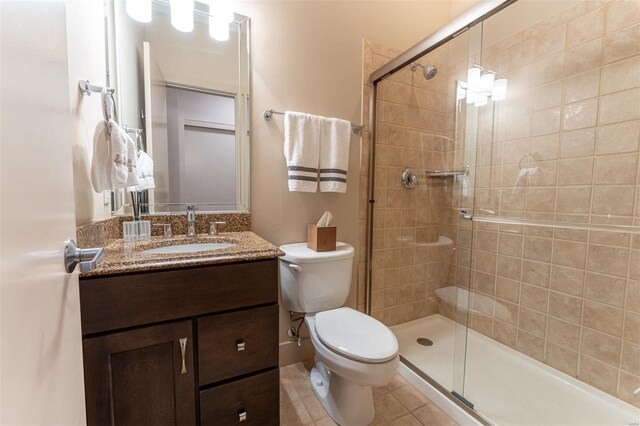 bathroom with walk in shower, tile patterned floors, toilet, and vanity