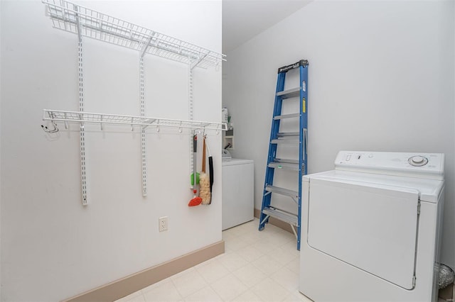 clothes washing area featuring light tile patterned flooring and washing machine and dryer