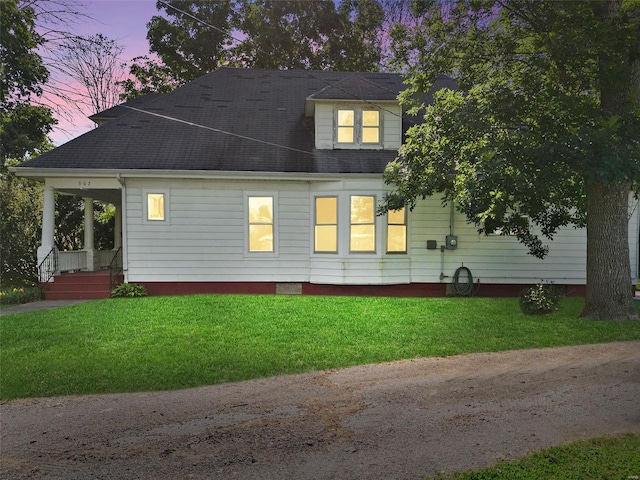 property exterior at dusk with a yard