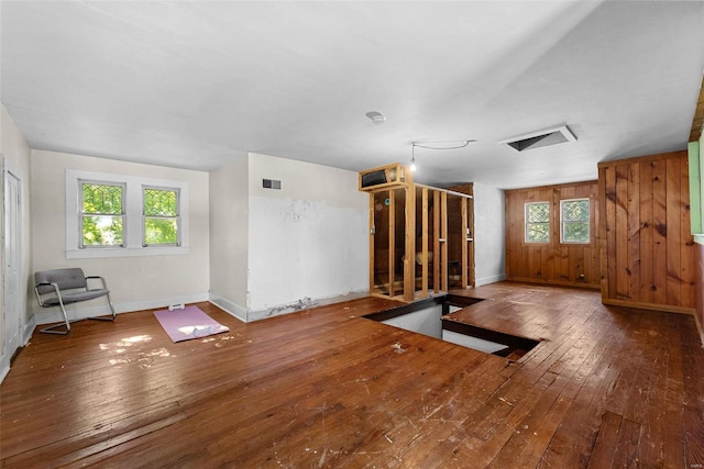 exercise room featuring hardwood / wood-style floors and wooden walls