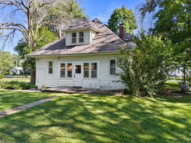 rear view of house featuring a lawn