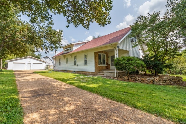 view of front of house with an outdoor structure, a garage, a front lawn, and covered porch