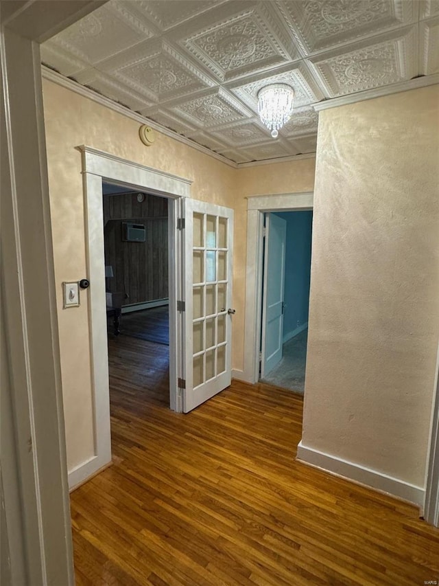 hallway with hardwood / wood-style floors and an inviting chandelier