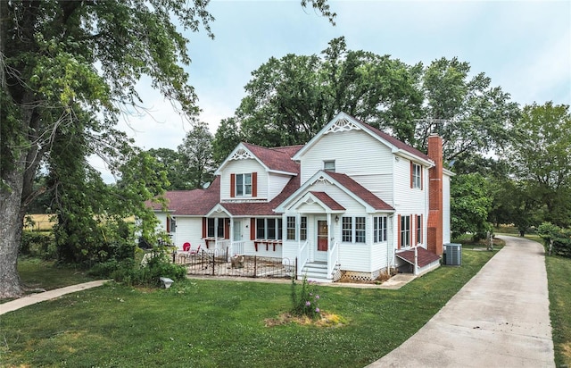 rear view of house featuring central air condition unit, a yard, and covered porch