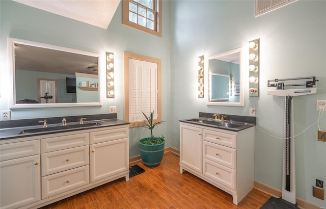 bathroom with double vanity and hardwood / wood-style flooring