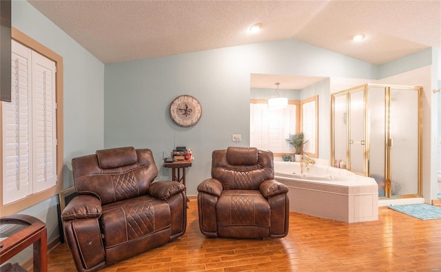 living room with light wood-type flooring, a textured ceiling, and lofted ceiling