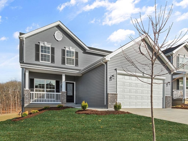 view of front of home with covered porch, a front yard, and a garage