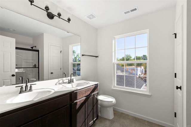 bathroom with tile patterned floors, toilet, vanity, and walk in shower