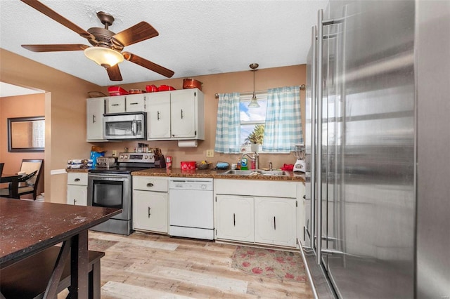 kitchen featuring sink, light hardwood / wood-style floors, decorative light fixtures, white cabinets, and appliances with stainless steel finishes