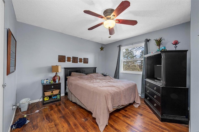 bedroom featuring a textured ceiling, ceiling fan, and dark wood-type flooring