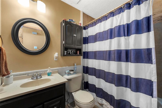 bathroom featuring a shower with curtain, vanity, toilet, and a textured ceiling