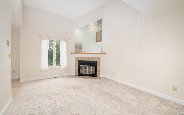 unfurnished living room with light colored carpet and a fireplace