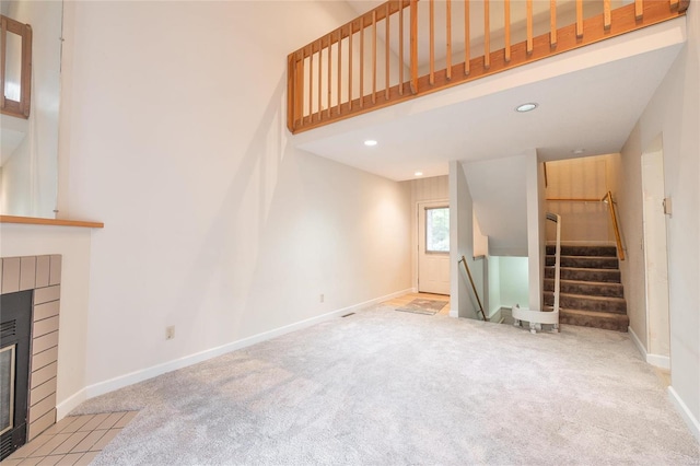 unfurnished living room featuring a brick fireplace and light colored carpet