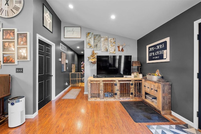 living room featuring vaulted ceiling and hardwood / wood-style flooring