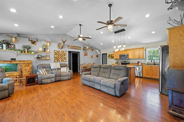 living room with hardwood / wood-style flooring, ceiling fan, lofted ceiling, and sink