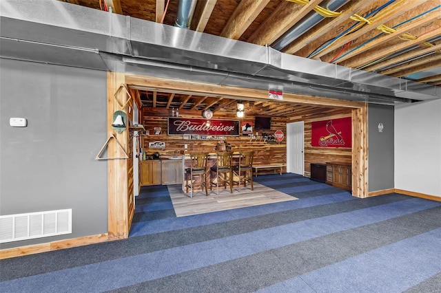 basement with carpet floors and bar area