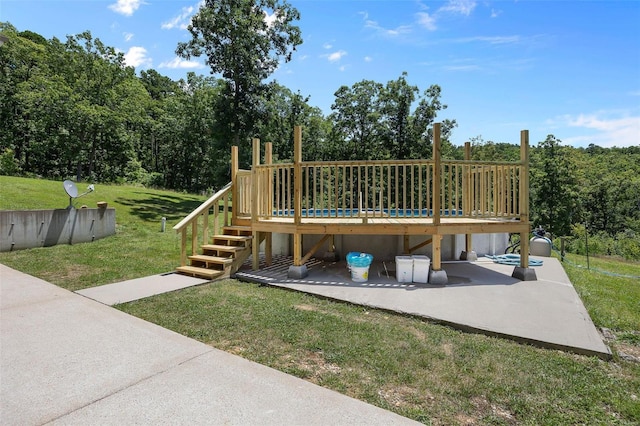 view of jungle gym featuring a wooden deck, a yard, and a patio area