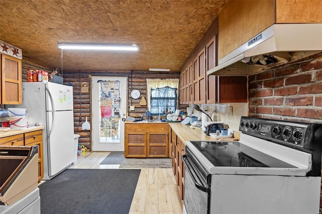 kitchen featuring sink, white appliances, brick wall, range hood, and light wood-type flooring