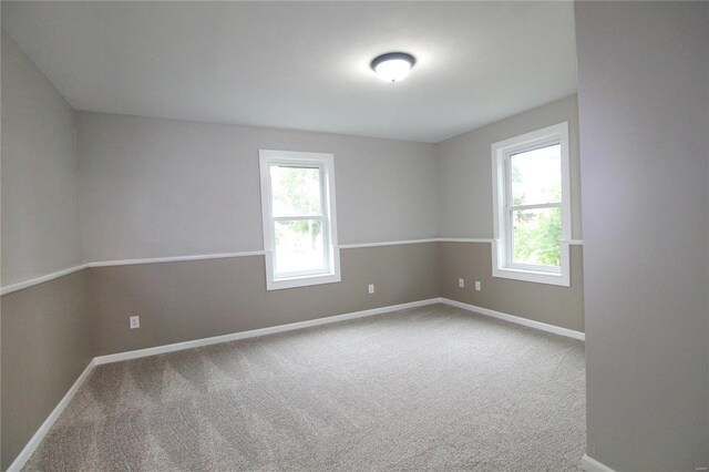 carpeted spare room featuring a wealth of natural light