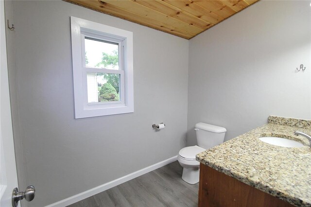 bathroom featuring hardwood / wood-style flooring, wood ceiling, toilet, and vanity