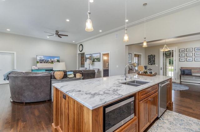 kitchen with ceiling fan, sink, a center island with sink, dark hardwood / wood-style floors, and appliances with stainless steel finishes