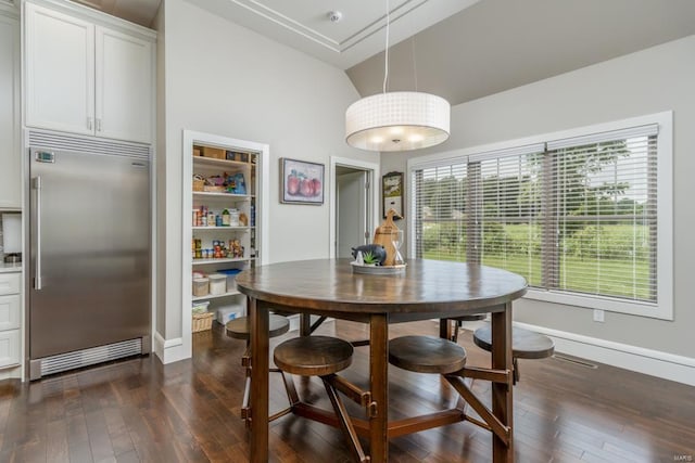 dining room featuring lofted ceiling, built in shelves, and dark hardwood / wood-style flooring