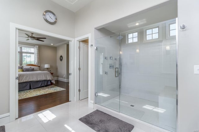 bathroom with a shower with shower door, ceiling fan, and tile patterned floors