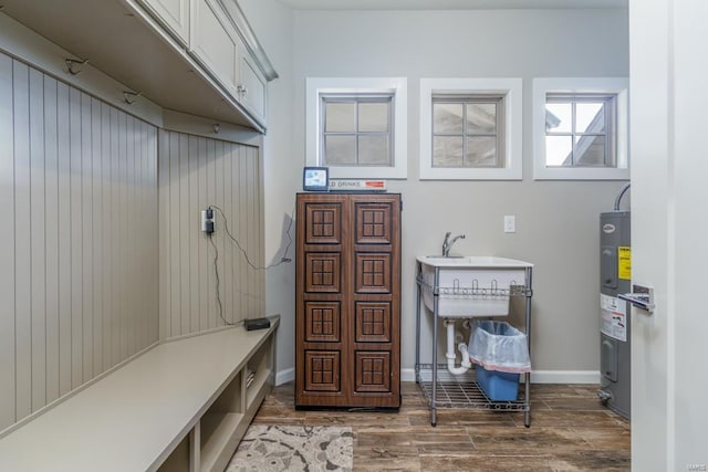 mudroom with electric water heater and dark wood-type flooring