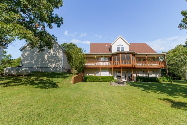 back of property with a yard and a wooden deck