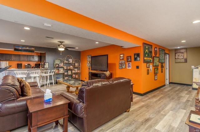 living room featuring light hardwood / wood-style flooring and ceiling fan