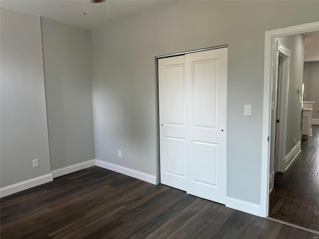 unfurnished bedroom with dark wood-type flooring