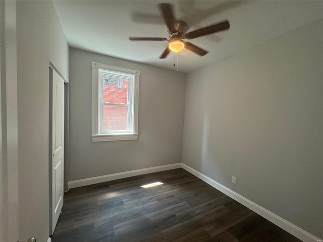 spare room with ceiling fan and dark wood-type flooring