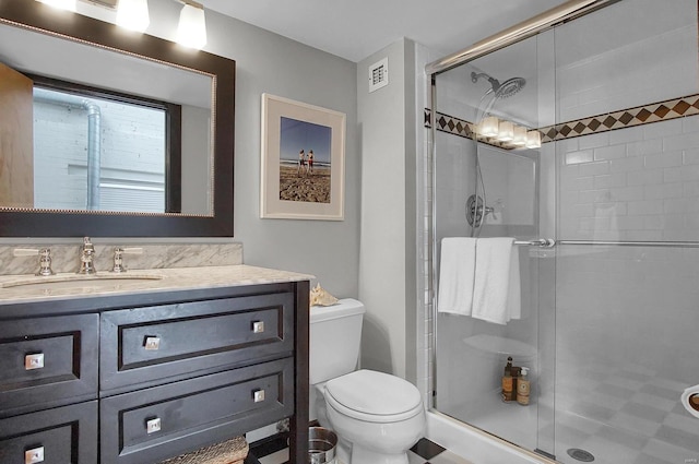 bathroom with walk in shower, vanity, and toilet