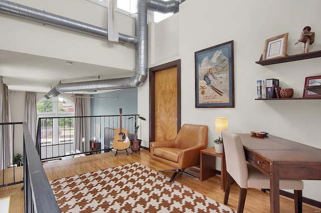 interior space with a towering ceiling and light hardwood / wood-style floors