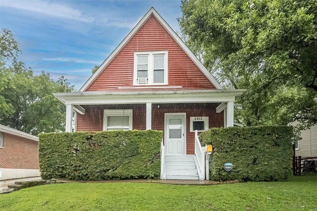 view of front of property featuring covered porch and a front lawn