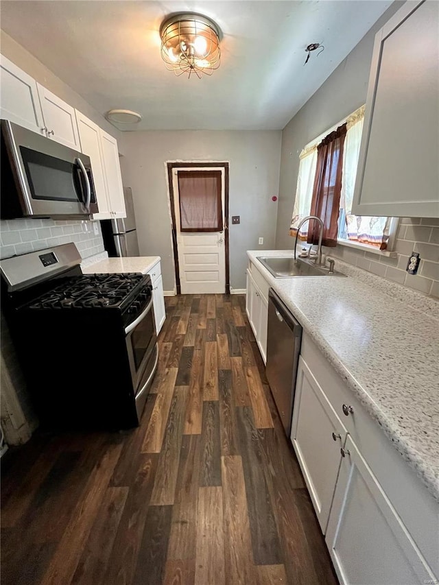 kitchen featuring sink, white cabinetry, appliances with stainless steel finishes, and decorative backsplash