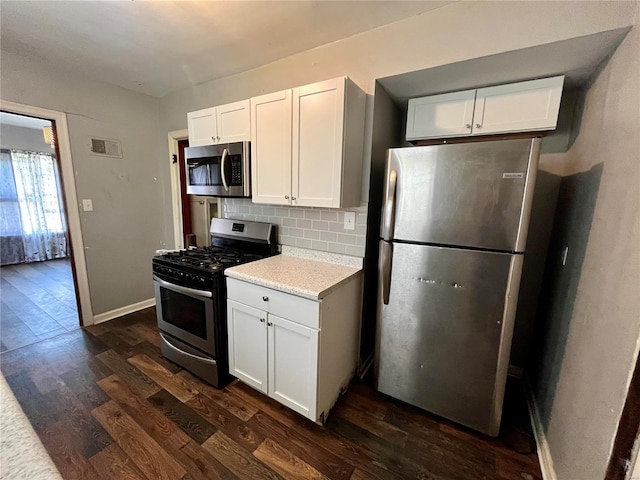 kitchen with white cabinets, tasteful backsplash, dark hardwood / wood-style floors, and appliances with stainless steel finishes