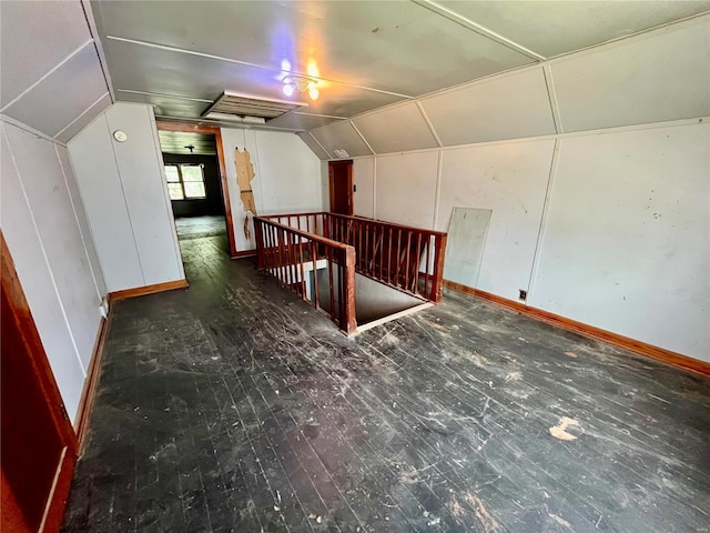 additional living space with dark wood-type flooring and lofted ceiling