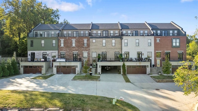 multi unit property featuring a garage and driveway