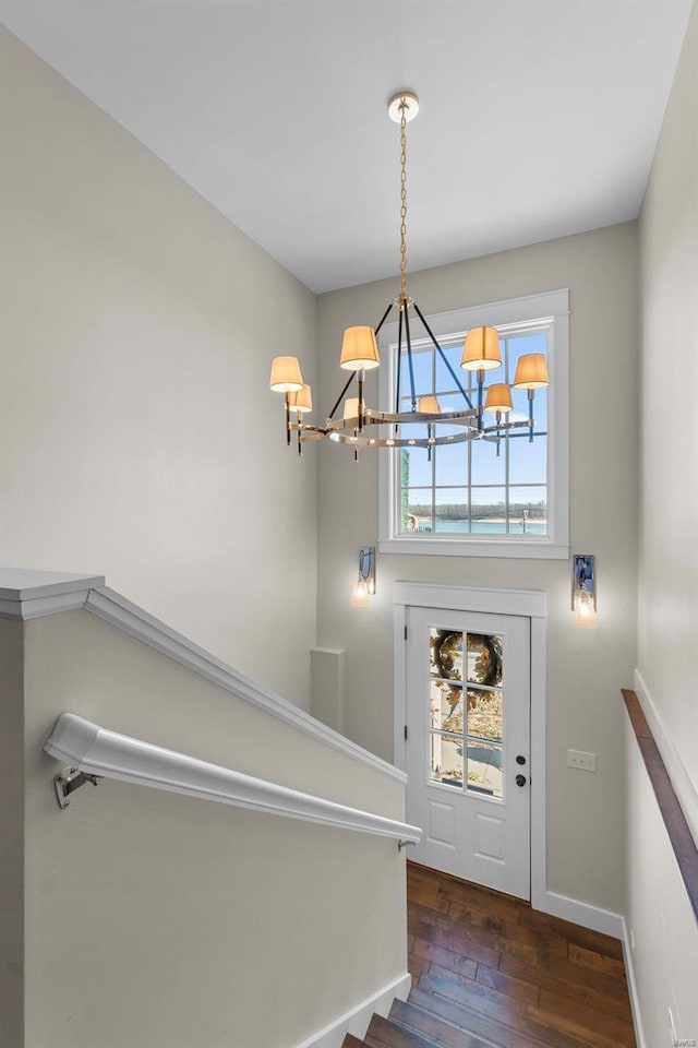 entrance foyer featuring baseboards, a notable chandelier, and hardwood / wood-style floors