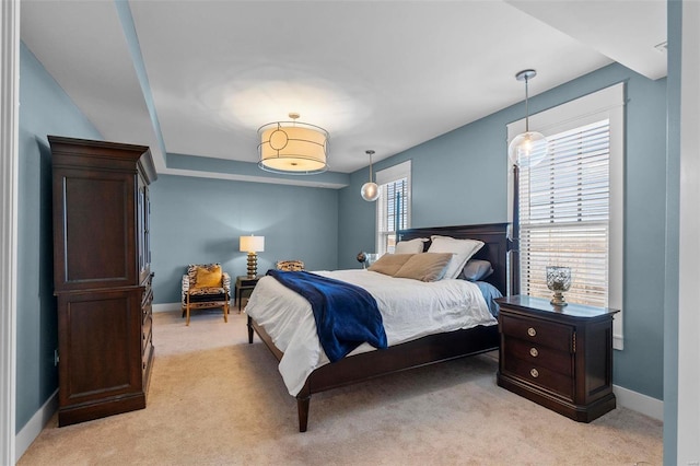 bedroom with light colored carpet and baseboards