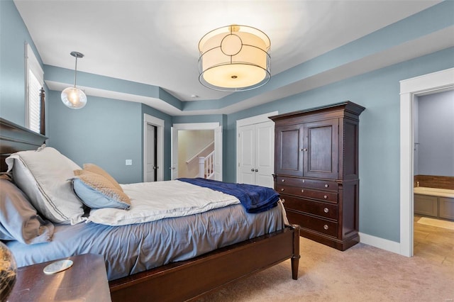 bedroom with baseboards, a closet, and light colored carpet